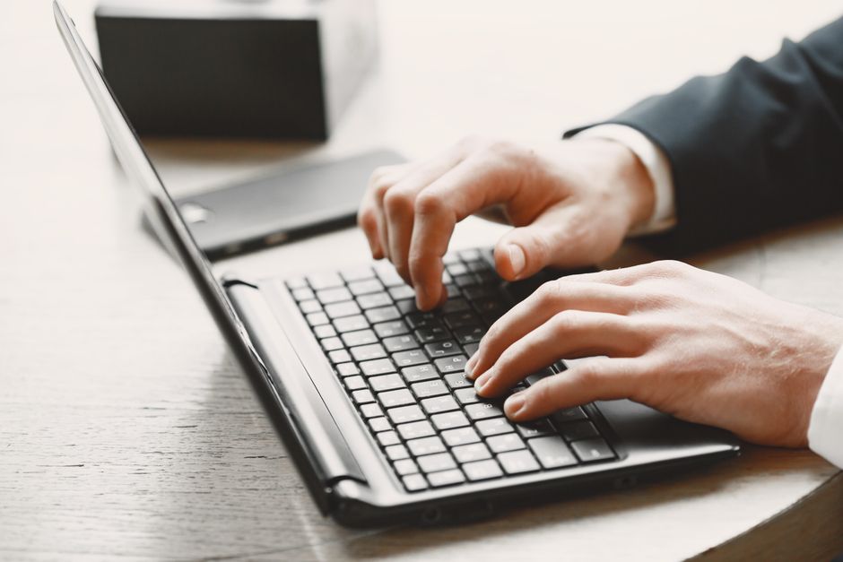 Close-up of hands typing on a laptop in a focused research setting