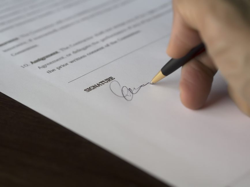 Close-up of a hand signing a business contract, representing MRR license terms