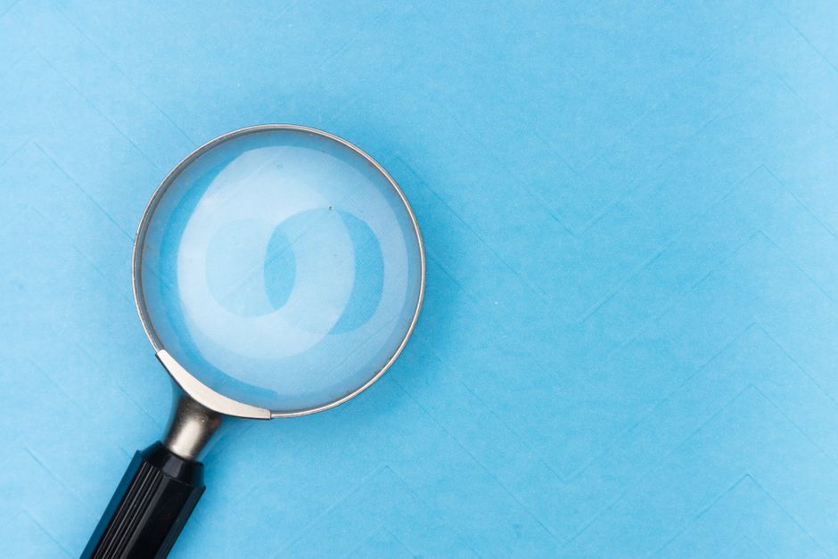 Magnifying glass over search and keyword text, representing SEO research for a listing