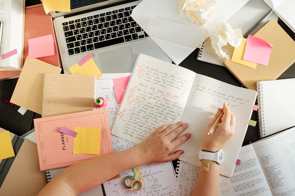 Person taking research notes in a notebook while validating a product idea